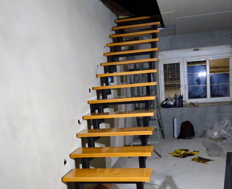 Interiérové schodiště s výraznými dřevěnými stupni během realizace