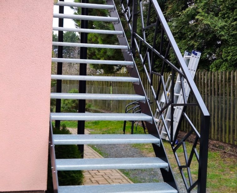 Venkovní kovové schodiště s designovým zábradlím u domu